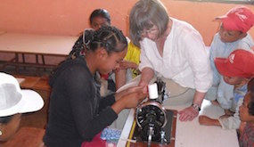 Women leaning over sewing machines